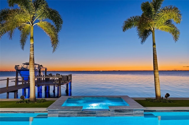 dock area featuring a water view and a pool with connected hot tub