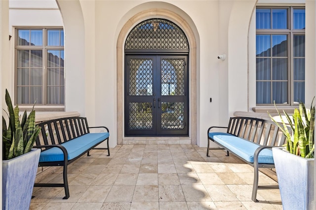 doorway to property featuring stucco siding and french doors