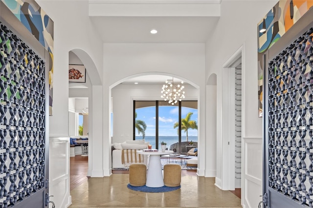 foyer with recessed lighting, a water view, and crown molding