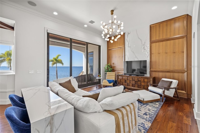 living area featuring ornamental molding, a chandelier, visible vents, and hardwood / wood-style flooring