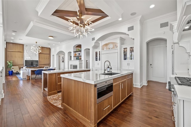 kitchen with a notable chandelier, dark wood-style flooring, a spacious island, a sink, and visible vents