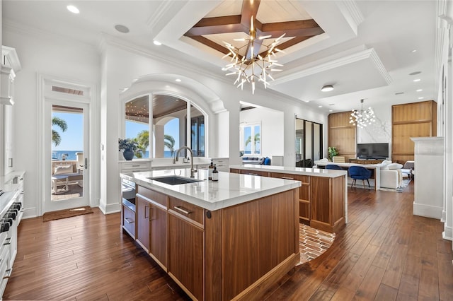 kitchen with brown cabinets, a sink, and an island with sink