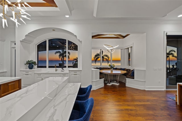 interior space with hardwood / wood-style floors, an inviting chandelier, crown molding, pendant lighting, and a sink