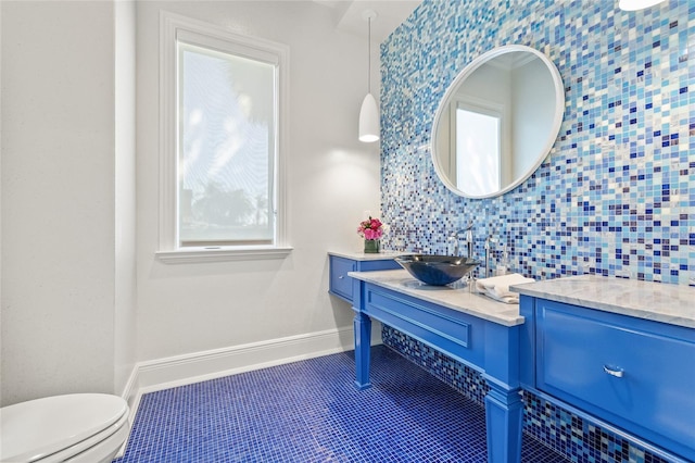 bathroom featuring plenty of natural light, vanity, baseboards, and tile patterned floors