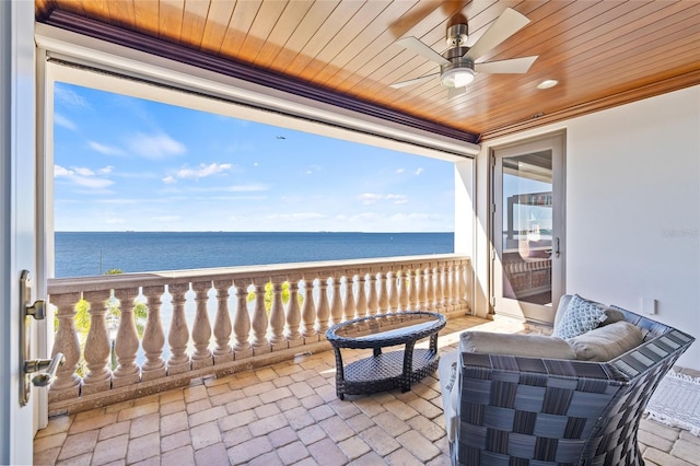 view of patio with a water view, a view of the beach, and a ceiling fan