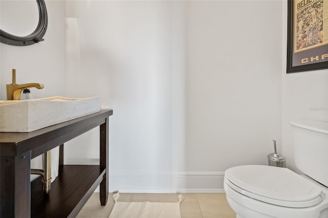 bathroom with baseboards, toilet, and tile patterned floors