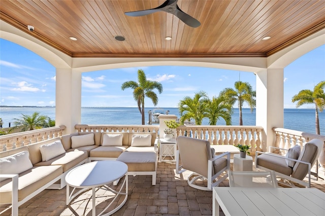 view of patio / terrace with a water view, an outdoor hangout area, and a ceiling fan