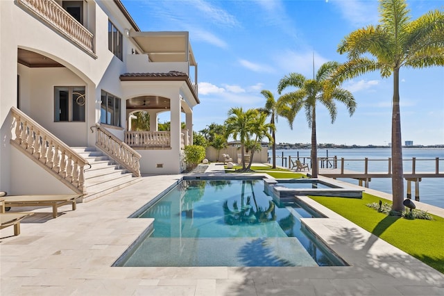 view of swimming pool with a water view, a pool with connected hot tub, stairs, and a patio