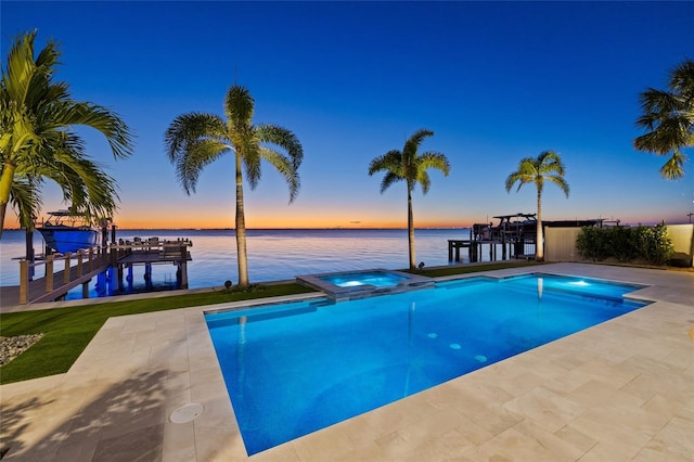 pool at dusk with a dock, a water view, and a pool with connected hot tub