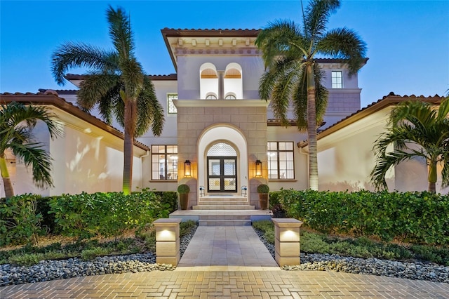 view of exterior entry featuring stucco siding and french doors