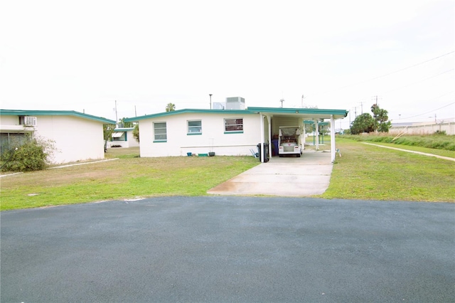 manufactured / mobile home featuring central AC, a front lawn, a carport, and concrete driveway