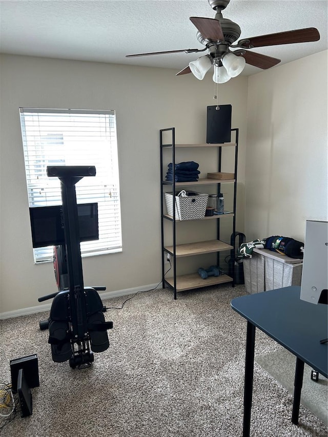 exercise area with a textured ceiling and baseboards