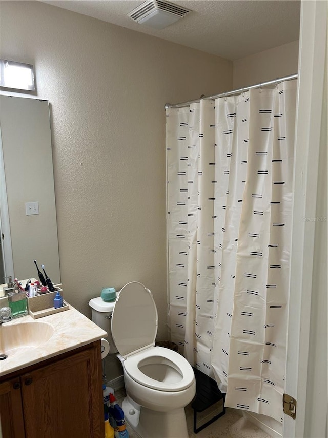 full bath featuring visible vents, a textured wall, toilet, vanity, and a textured ceiling