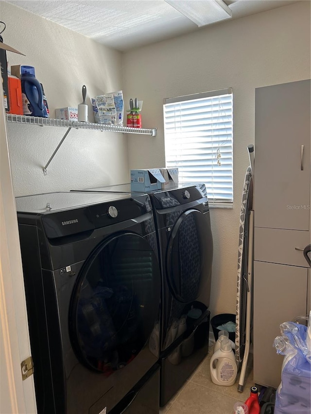 washroom featuring laundry area, washer and clothes dryer, and tile patterned floors