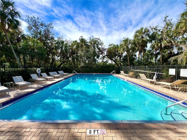 pool with fence and a patio