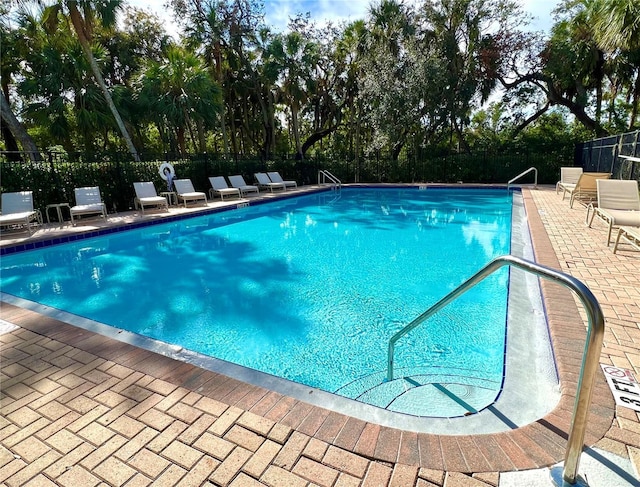 community pool featuring a patio and fence