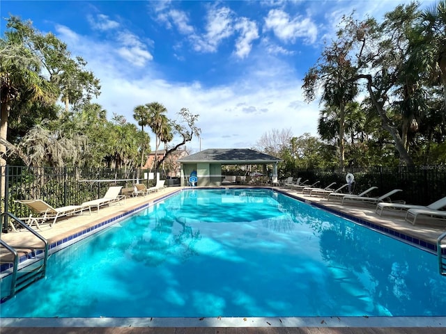 community pool with a gazebo, a patio, and fence