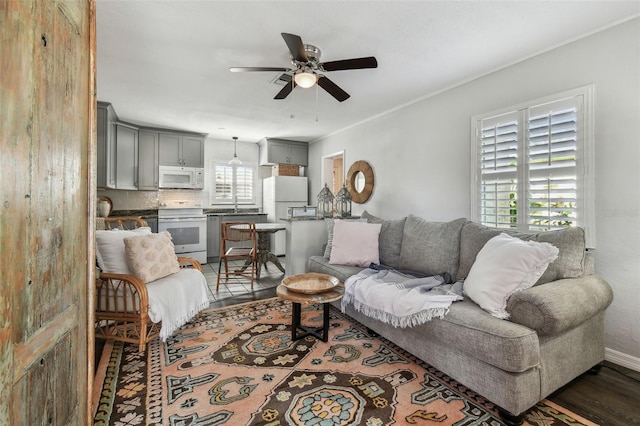 living room with ceiling fan, dark wood-style floors, and baseboards