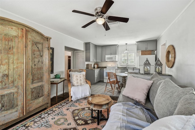 living area featuring a ceiling fan and light tile patterned floors