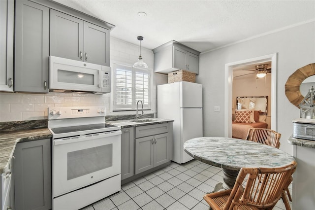 kitchen featuring white appliances, light tile patterned floors, a sink, gray cabinetry, and backsplash