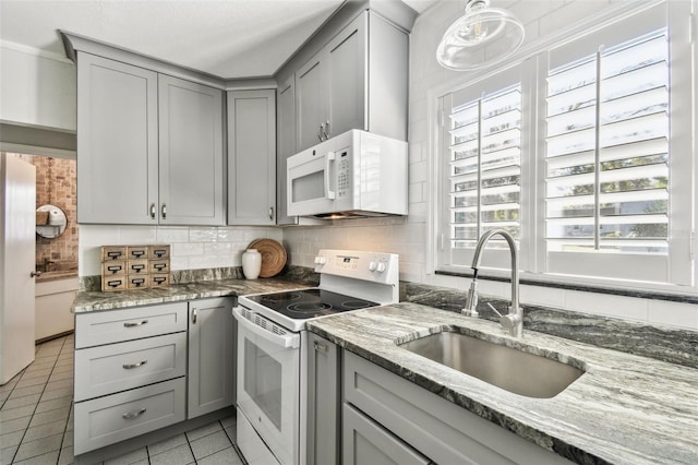 kitchen featuring white appliances, decorative backsplash, gray cabinets, a sink, and light tile patterned flooring