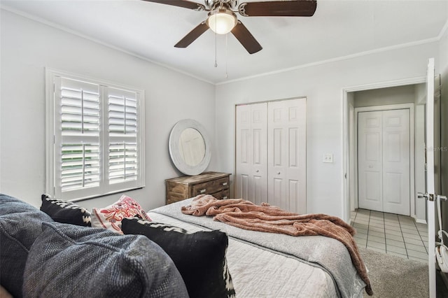 tiled bedroom featuring a closet, a ceiling fan, and crown molding