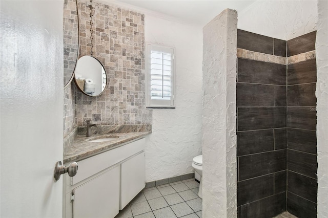 bathroom featuring a textured wall, vanity, toilet, and tile patterned floors