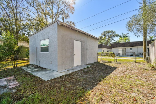 view of outbuilding with a gate, fence, and an outdoor structure