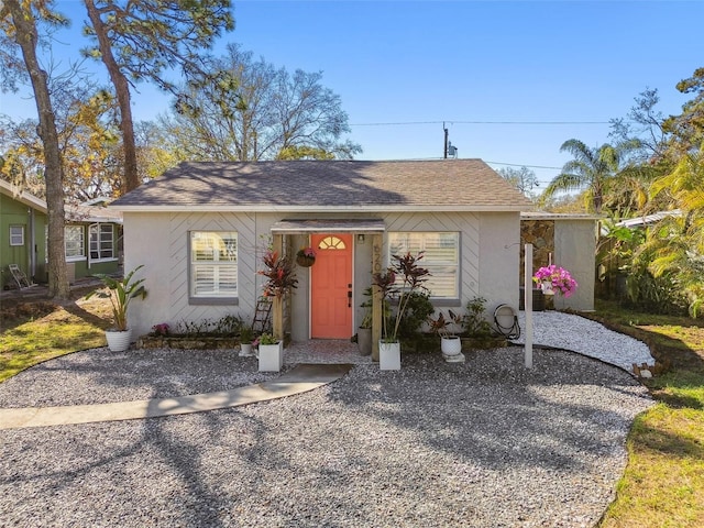 single story home with roof with shingles and stucco siding