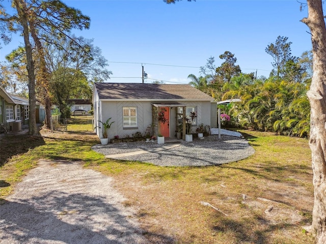 view of front of property with a front lawn, cooling unit, and stucco siding