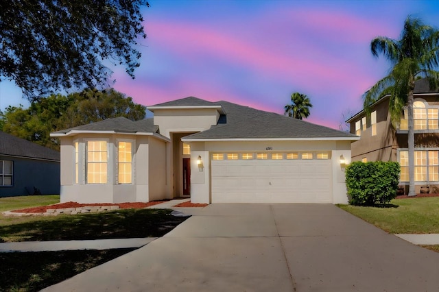 view of front facade with driveway, an attached garage, and stucco siding