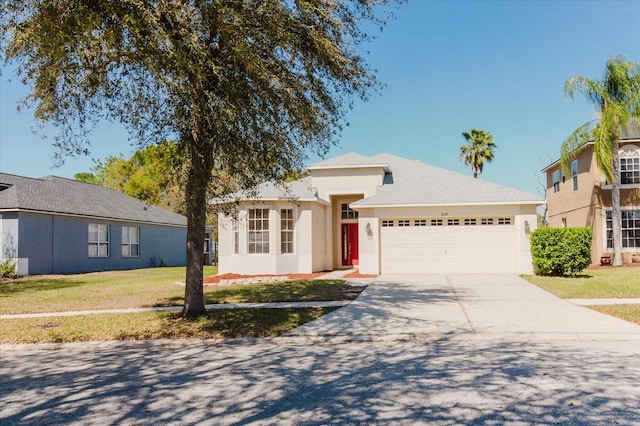 single story home with a garage, a front yard, concrete driveway, and stucco siding