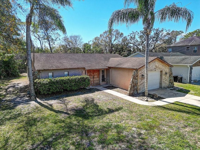 view of front facade with driveway, stucco siding, an attached garage, and a front yard