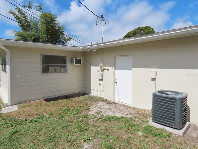 exterior space with central AC and a yard