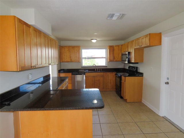 kitchen featuring visible vents, appliances with stainless steel finishes, a peninsula, a sink, and light tile patterned flooring