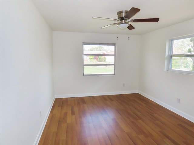 empty room featuring a ceiling fan, baseboards, and wood finished floors