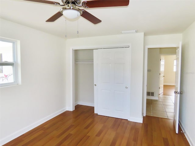 unfurnished bedroom featuring a closet, visible vents, and wood finished floors