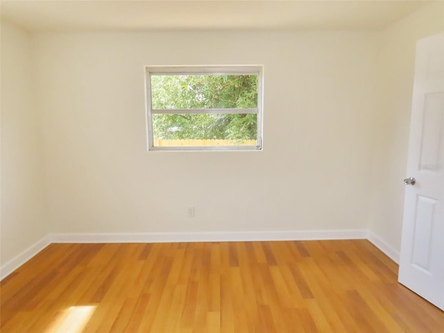 empty room featuring light wood finished floors and baseboards