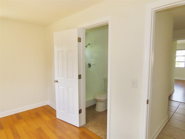 bathroom with tile patterned flooring, baseboards, and toilet