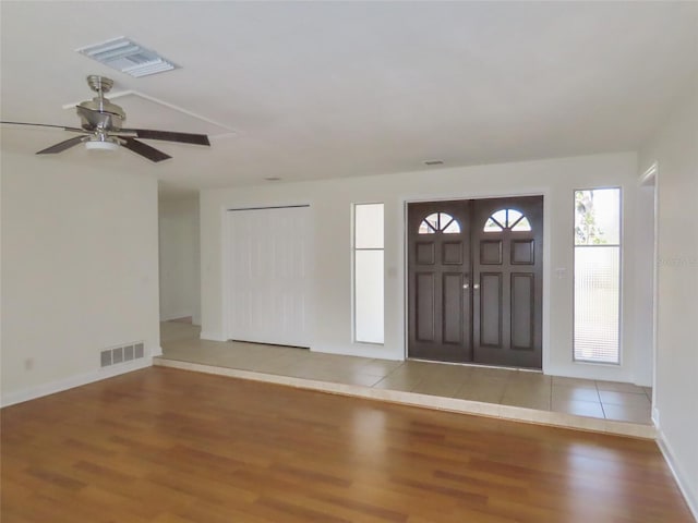 entrance foyer featuring visible vents, ceiling fan, baseboards, and wood finished floors