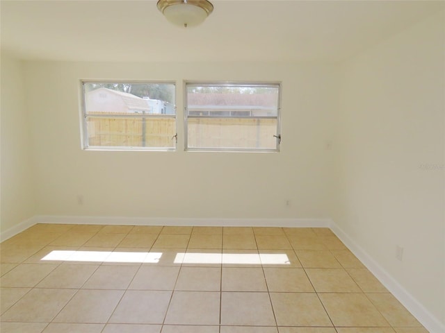 unfurnished room featuring light tile patterned floors and baseboards