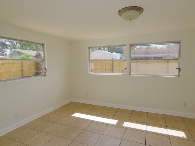 unfurnished room with baseboards and tile patterned floors