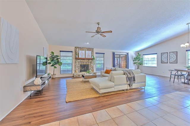 living room with vaulted ceiling, a textured ceiling, a fireplace, and wood finished floors