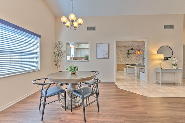 dining room featuring a chandelier, visible vents, and wood finished floors