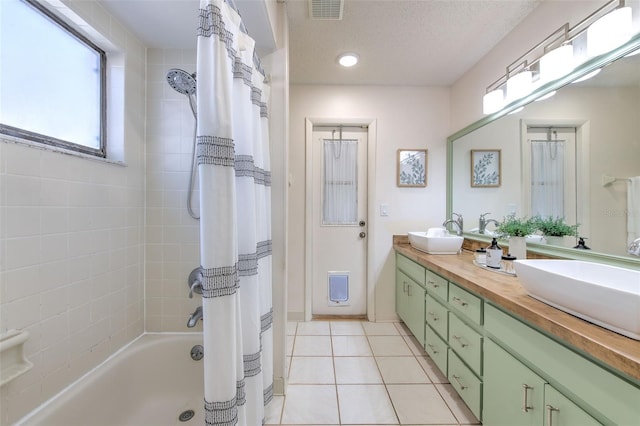 bathroom featuring tile patterned flooring, visible vents, a sink, and a textured ceiling