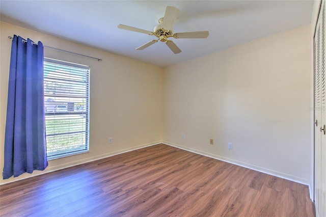 unfurnished room with ceiling fan, wood finished floors, and baseboards