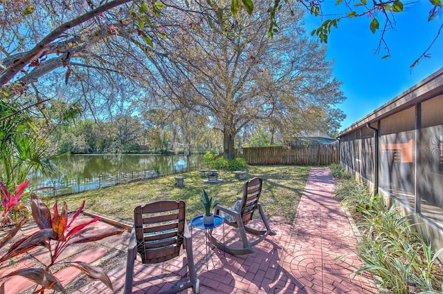 view of patio / terrace with a water view and fence