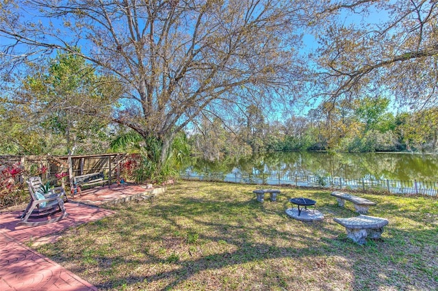 view of yard with a water view, a patio area, and a fenced backyard