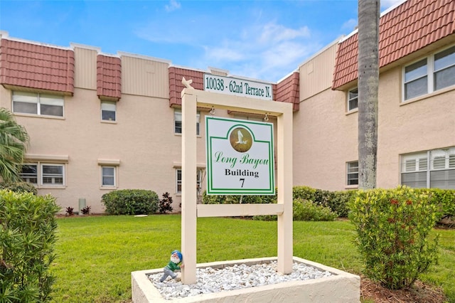 community / neighborhood sign featuring a yard