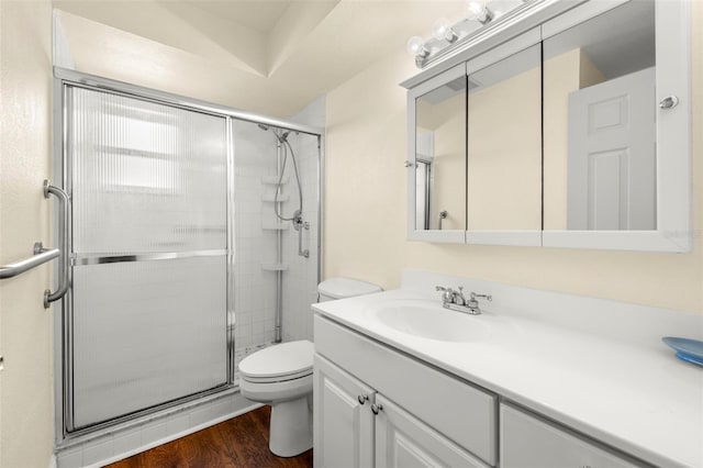 full bathroom featuring vanity, wood finished floors, a shower stall, and toilet